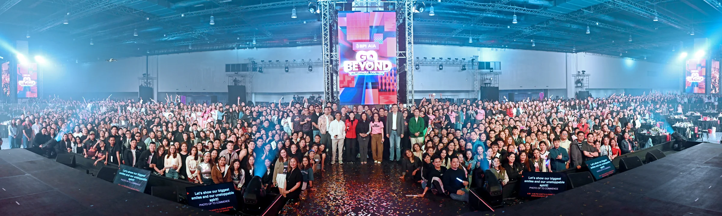 AIA commitment-setting event with a packed audience and branded stage.